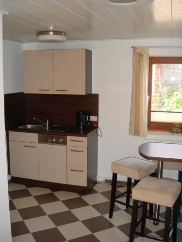 a kitchen with a sink and a table with stools at Kietzke in Eckernförde