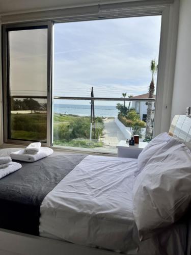 a bedroom with a large window with a view of the ocean at Luxury Villa Azure in Larnaca