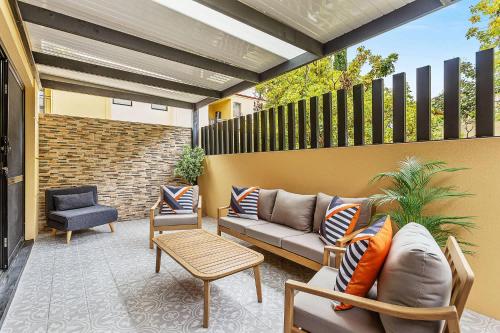 a patio with a couch and a table and a chair at Renovated Townhouse in Northbridge in Perth