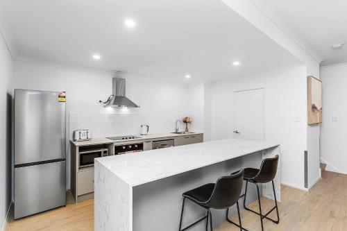 a kitchen with a large white counter top and a refrigerator at Renovated Townhouse in Northbridge in Perth