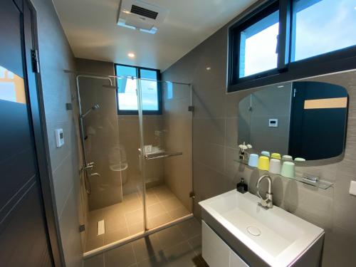 a bathroom with a glass shower and a sink at 樂山水休閒農園 in Dongshan