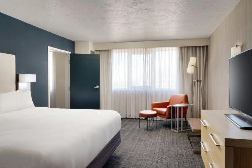 a hotel room with a bed and a desk and chair at Courtyard by Marriott Ogden in Ogden