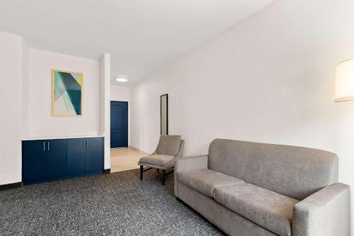 a living room with a couch and a chair at Spark By Hilton Missouri City in Missouri City