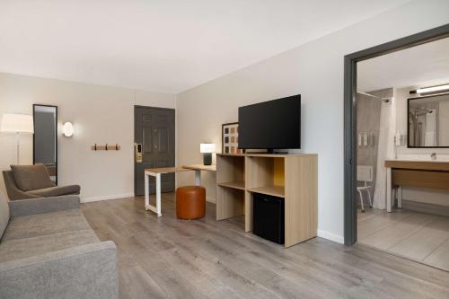 a living room with a flat screen tv and a couch at Spark by Hilton Rock Springs in Rock Springs