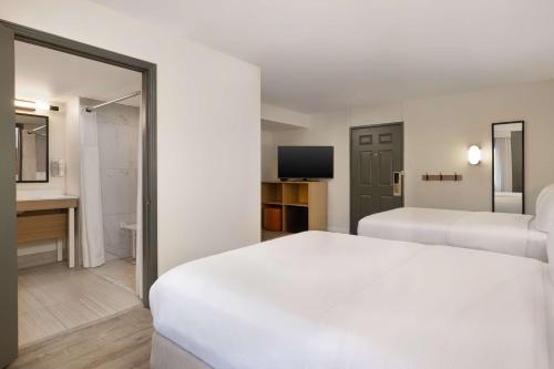 a hotel room with two beds and a television at Spark by Hilton Rock Springs in Rock Springs