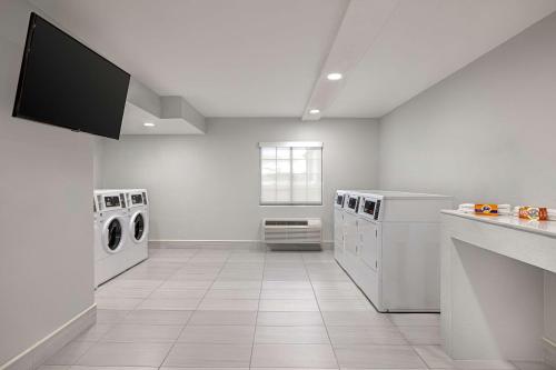a white laundry room with washing machines and a window at Spark by Hilton Rock Springs in Rock Springs