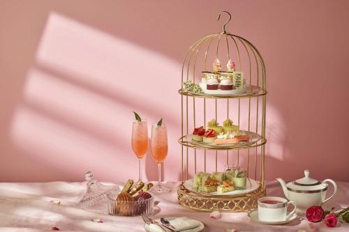 a table with a bird cage with pastries and drinks at Josun Palace, a Luxury Collection Hotel, Seoul Gangnam in Seoul