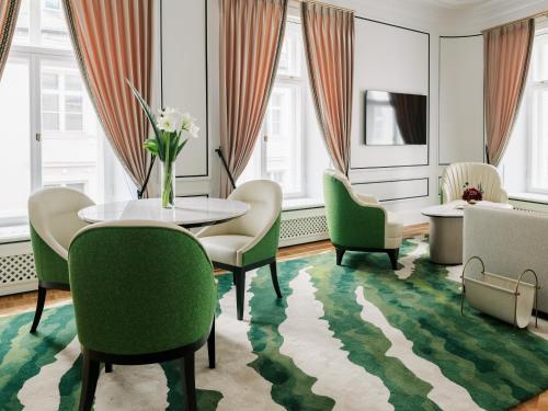 a dining room with a table and green chairs at The Burman Hotel in Tallinn