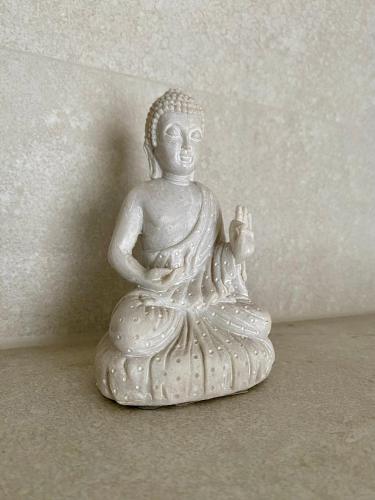 a white statue of a buddha sitting on the floor at Sonnensteinzimmer in Pirna