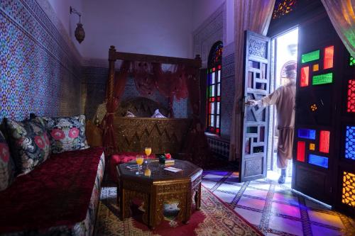 a man standing in a living room looking out a door at Riad Salam Fes in Fès