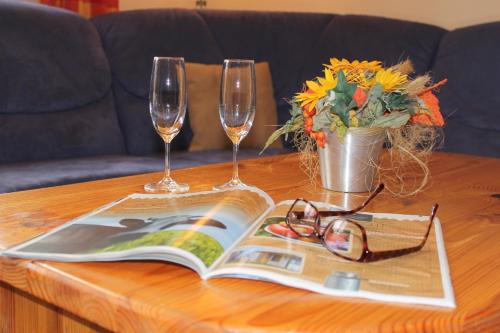 a table with two wine glasses and a book on it at "Hof Triangel - Whg 3" - Bauernhofurlaub in Riepsdorf
