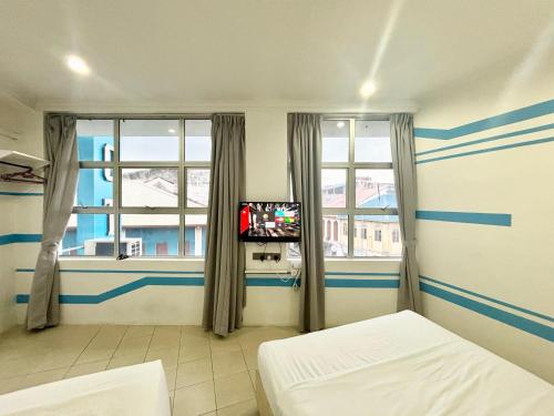 Postel nebo postele na pokoji v ubytování One Stop Hotel Ipoh
