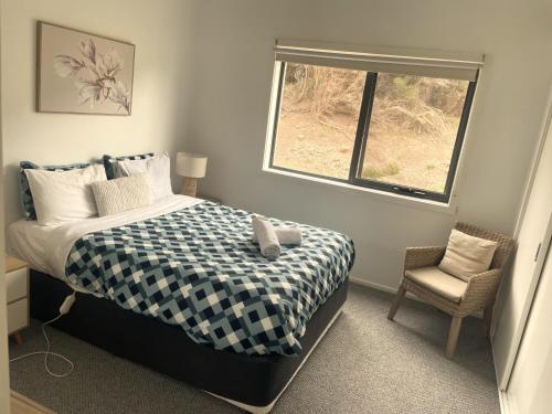 a bedroom with a bed and a window and a chair at 15 Whitecrest Great Ocean Road Resort - Ocean View in Apollo Bay
