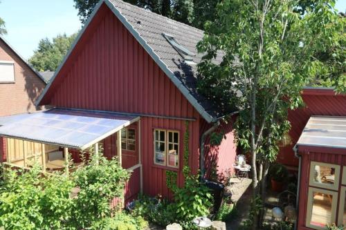 a red house with solar panels on the roof at Ferienhäuschen Neuberend in Neuberend