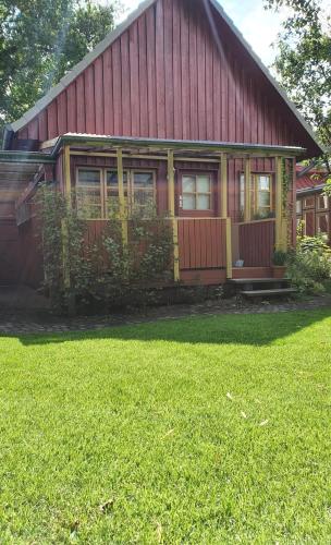 a red and yellow house with a green yard at Ferienhäuschen Neuberend in Neuberend