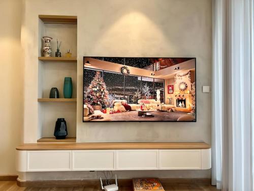 a television hanging on a wall in a living room at Landmark Ecopark by Emily in Town in Kim Quan