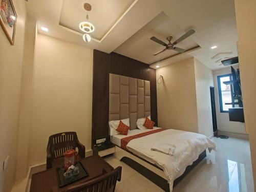 a bedroom with a bed and a table and a ceiling fan at Hotel Pink City in Sīkar