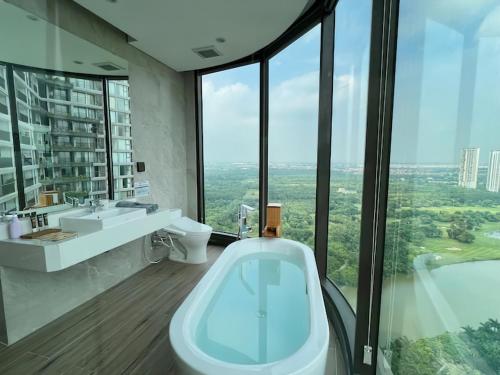 a bathroom with a tub and a sink and windows at Landmark Ecopark by Emily in Town in Kim Quan