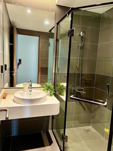 a bathroom with a sink and a shower at Landmark Ecopark by Emily in Town in Kim Quan
