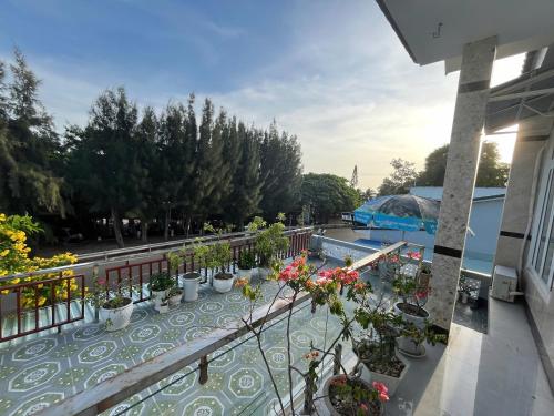 Lê Lộc Guesthouse في موي ني: شرفة مع نباتات الفخار وحمام سباحة
