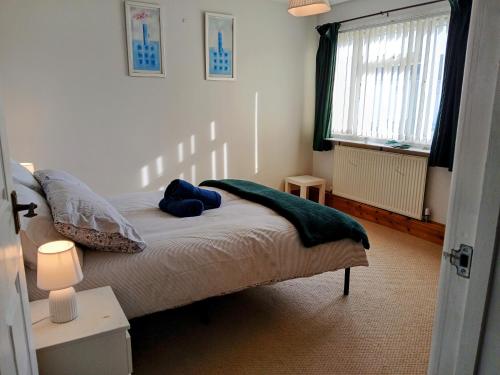 a bedroom with a bed with a green blanket on it at Ipswich Town 3 Bed House in Copdock