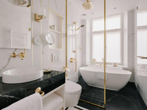 a bathroom with a tub and a toilet and a sink at The Burman Hotel in Tallinn