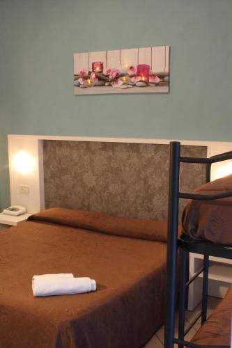 a bed with a towel on it in a room at Hotel Senyor in Rimini