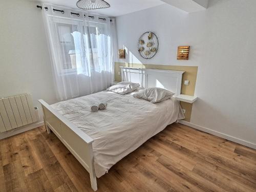 a bedroom with a white bed with two balls on it at Maisonette Cozy, Neuf, Centre-ville, Wifi in Elbeuf