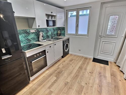 une cuisine avec un évier et une cuisinière dans l'établissement Maisonette Cozy, Neuf, Centre-ville, Wifi, à Elbeuf