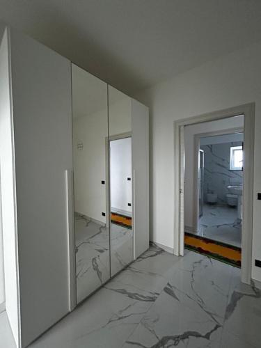 a white room with a mirror and a bathroom at Il Verde in Saluzzo