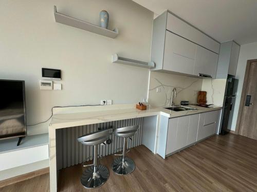 a kitchen with a counter and stools in a room at Landmark Ecopark by Emily in Town in Kim Quan