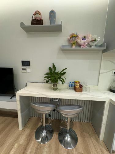 a kitchen with a counter with stools and shelves at Landmark Ecopark by Emily in Town in Kim Quan