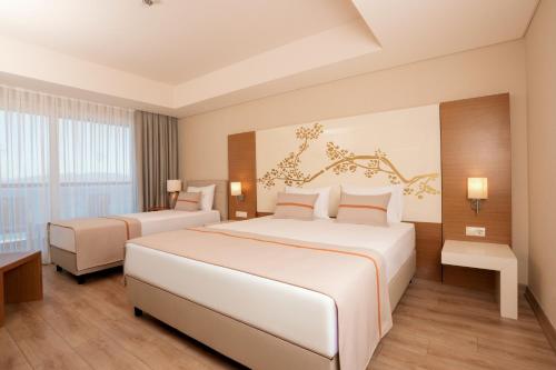 a hotel room with two beds and a window at Venosa Beach Resort & Spa - All Inclusive in Didim