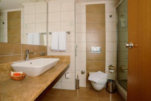 a bathroom with a sink and a toilet at Venosa Beach Resort & Spa - All Inclusive in Didim