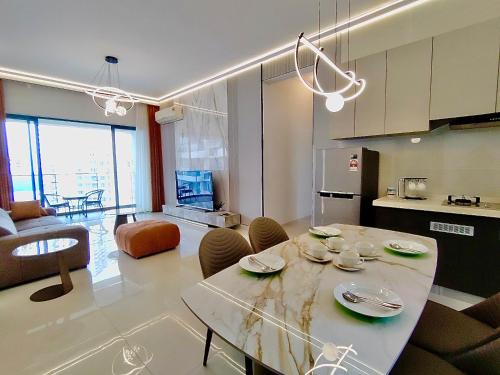Una cocina y una sala de estar con mesa y sillas. en Deluxe 3 Bed 3 Bath Apartment, en Johor Bahru