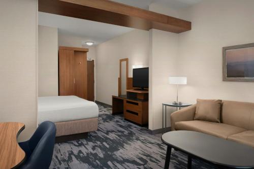 a hotel room with a bed and a couch and a table at Fairfield by Marriott The Dalles in The Dalles