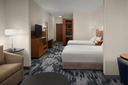 a hotel room with two beds and a couch at Fairfield by Marriott The Dalles in The Dalles
