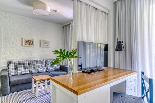 a living room with a tv and a couch at Hotel Shuum Boutique - Destigo Hotels in Kołobrzeg