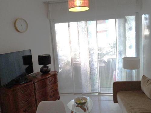 ein Wohnzimmer mit Sofa und Tisch in der Unterkunft Orée du Parc in Royan