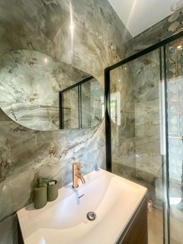 une salle de bain avec un lavabo et un miroir dans l'établissement Superbe villa vue mer et piscine, à Monticello