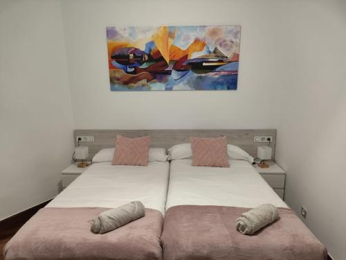 a bedroom with two beds and a painting on the wall at Nuevo, junto al Ayuntamiento y Casco Viejo in Bilbao