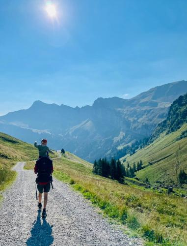 a man walking down a road with a child on his back at Chalet Grittli in Beckenried