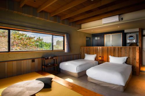 名護市にあるHotel Yagajisoのベッド2台と窓のある寝室