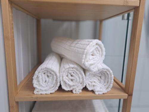 a pile of towels on a shelf in a bathroom at Zentrale Altbau Fewo Marktplatz in Gunzenhausen