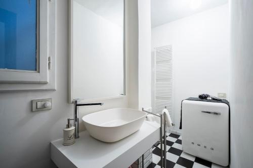 Un baño blanco con un lavabo sobre una encimera. en Orcagna Apartment, en Florencia