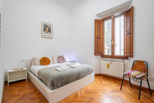 Un dormitorio blanco con una cama y una ventana. en Orcagna Apartment, en Florencia