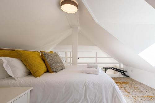 a bedroom with a white bed with yellow pillows at 4188 River Club in Plettenberg Bay