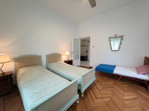 a room with two beds and a lamp in it at 1 Min Walk from the Sea, with 2 Bed and 2 Bath in Alassio