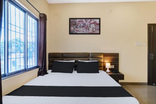 a bedroom with a large bed and large windows at Super Hotel O Lalganesh formerly Royal Avenue in Guwahati