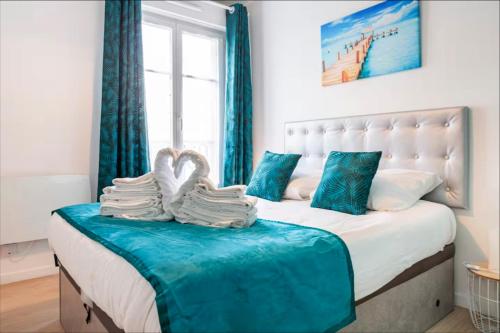 a bedroom with a bed with two towels on it at Casaminnie - Appartement à 8 min de Disneyland Paris in Bussy-Saint-Georges